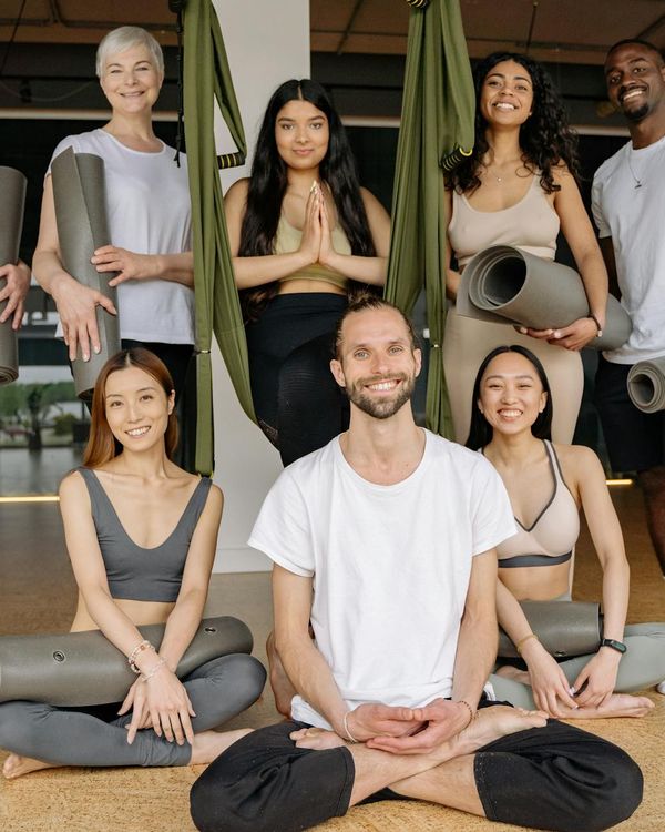 Diverse group of people smiling during a yoga class.
